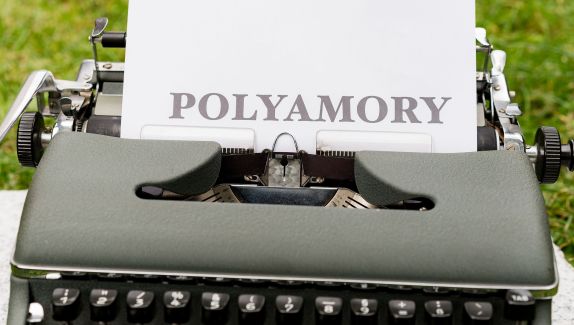 A typewriter with the word polyamory printed on the paper