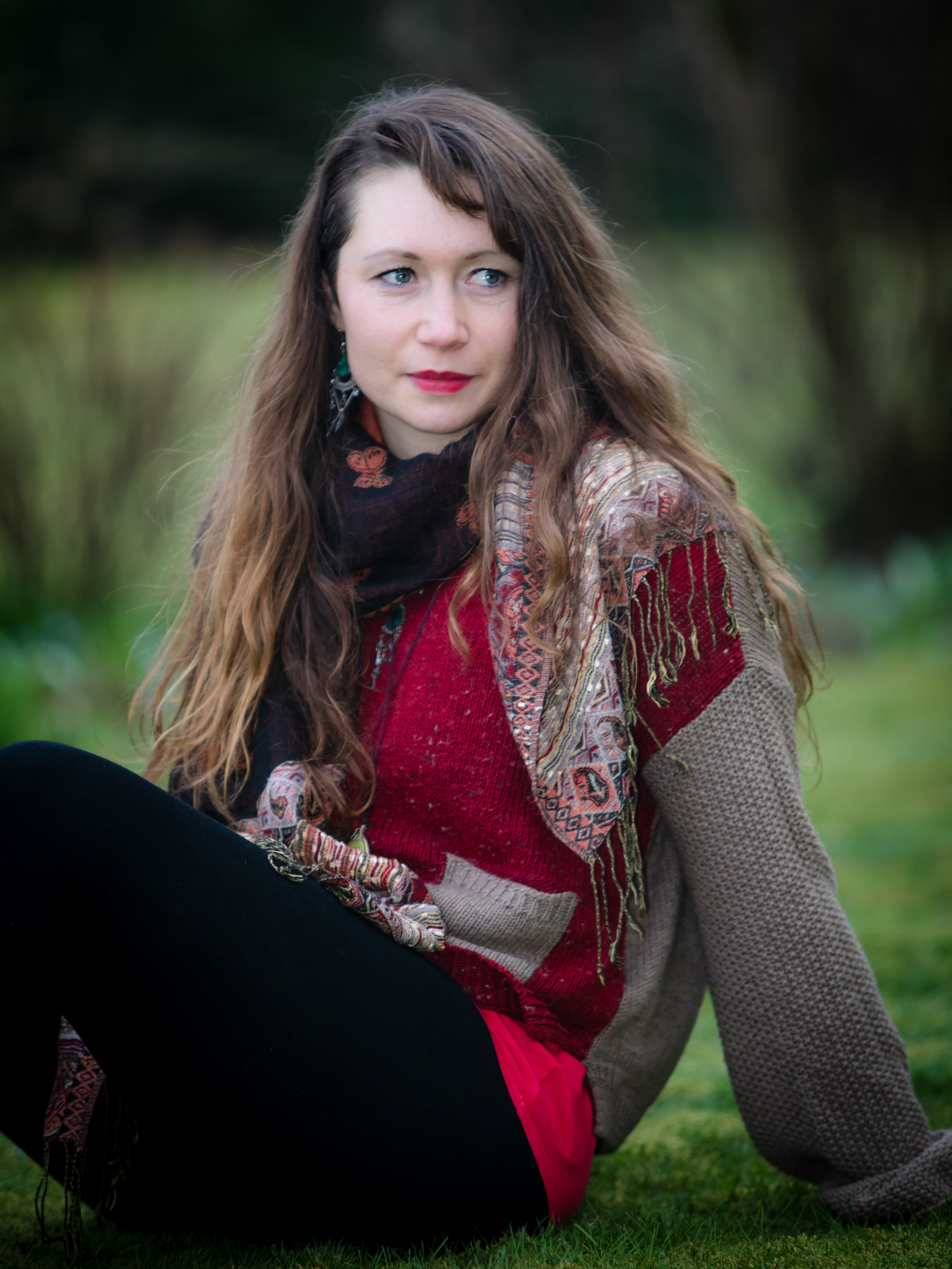 Emma K Harper sitting in a field looking thoughtfully